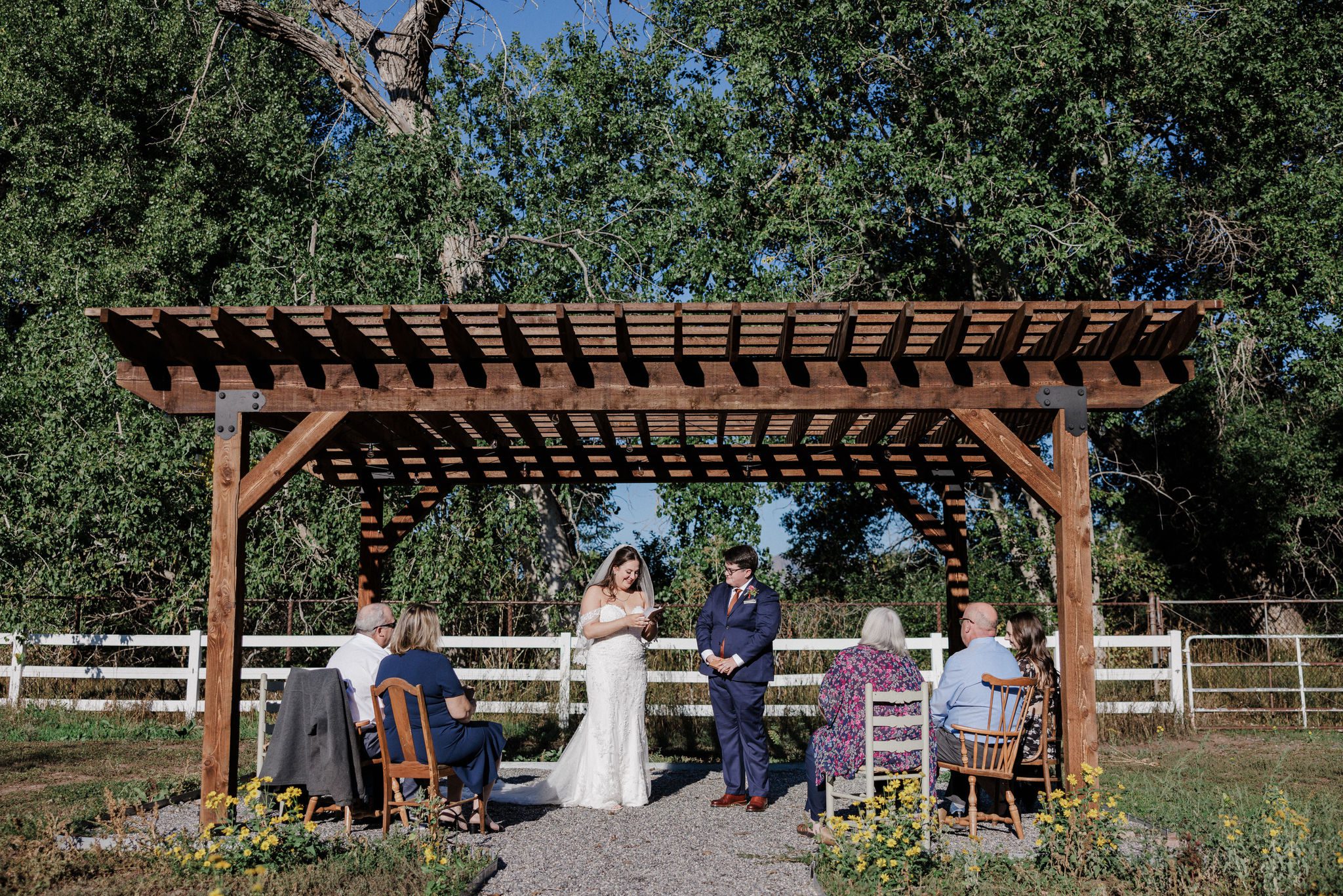 two brides say their wedding vows under a wooden structure during their rustic micro wedding in colorado
