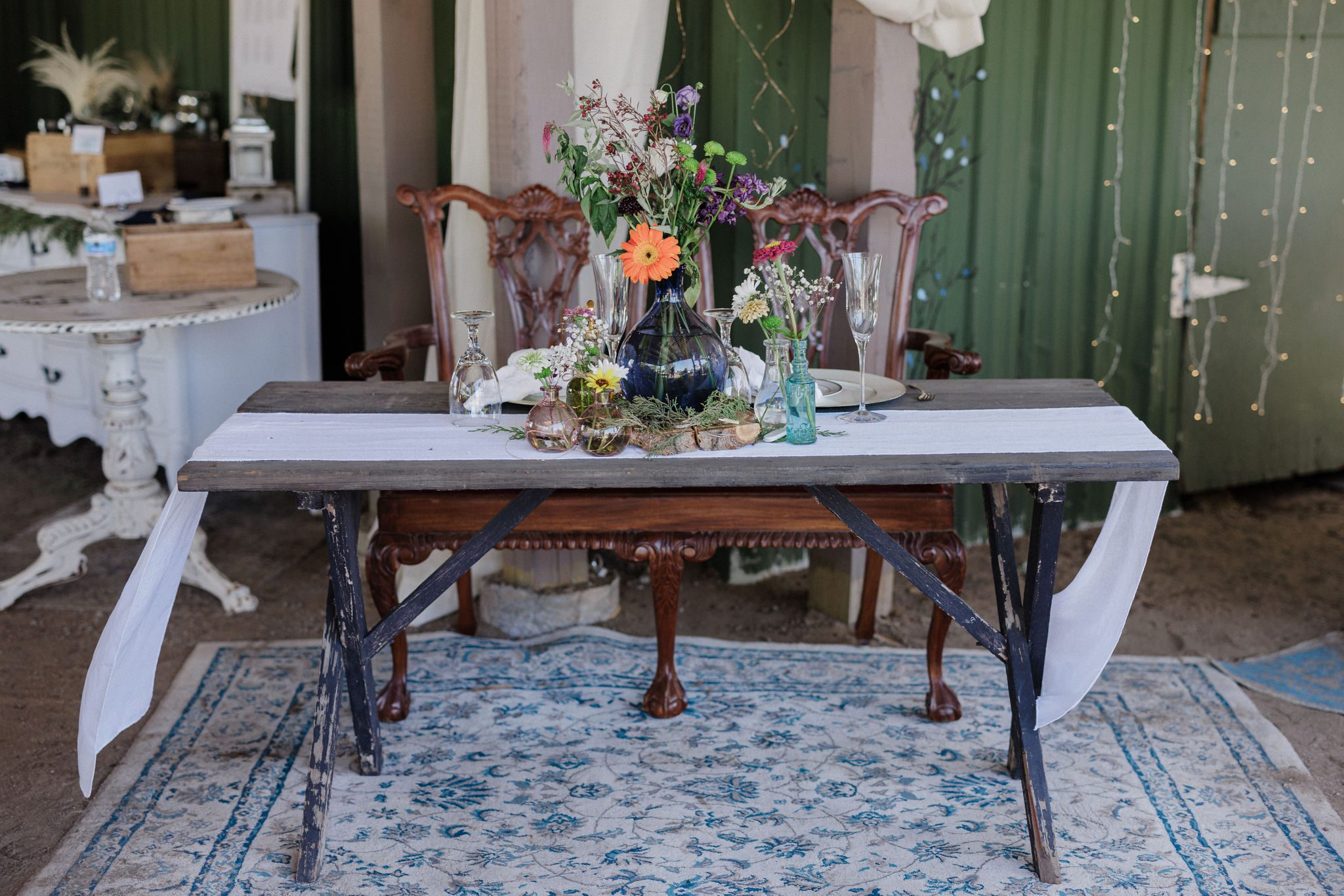 sweetheart table set up for the bride and groom, with rustic decor and wildflowers