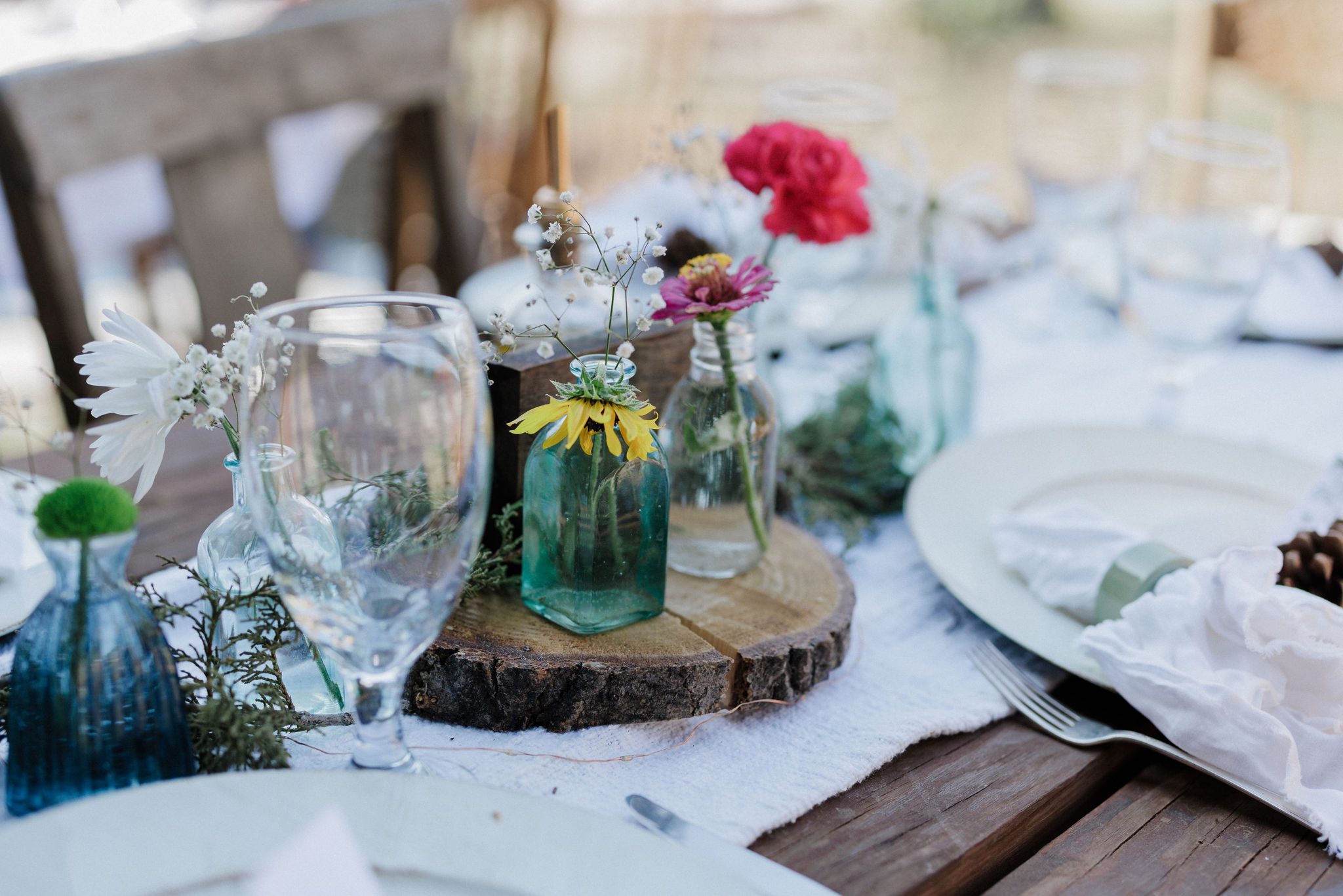 close up image of a wedding reception table with rustic decor and wildflowers