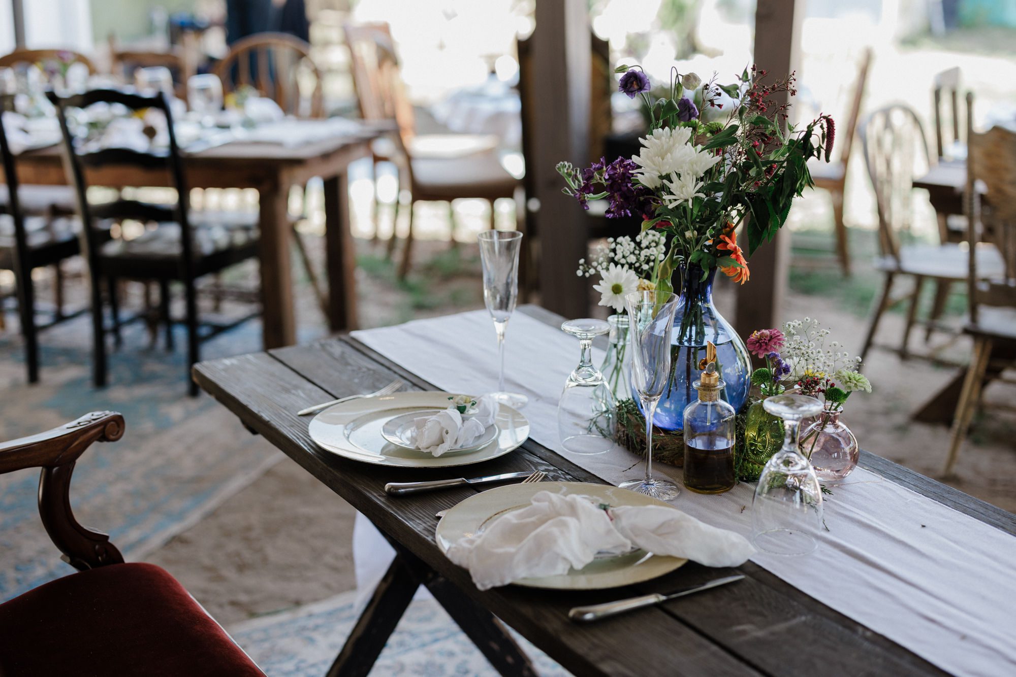 a table with wildflowers are set up for a rustic wedding in colorado