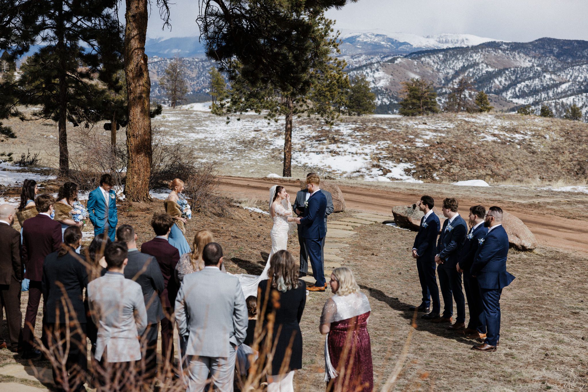 bride and groom say wedding vows, with guests watching, during colorado airbnb micro wedding