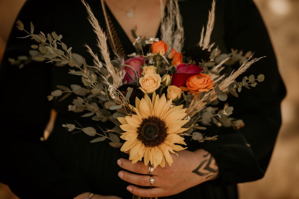 bride holds bouquet during colorado elopement at red rocks park.