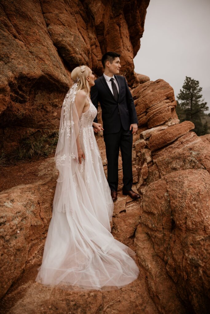 bride and groom stand in the red rocks at Garden of the Gods wedding in colorado springs.