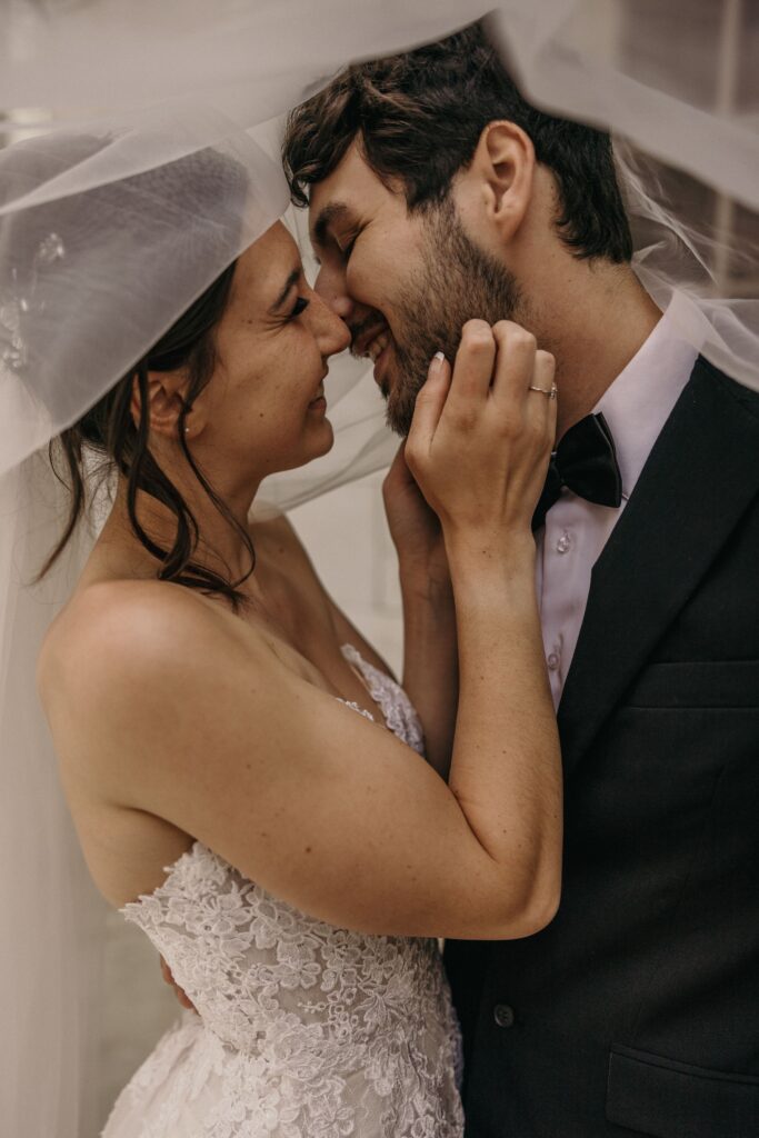 bride and groom kiss under veil during downtown denver elopement at byron white courthouse.