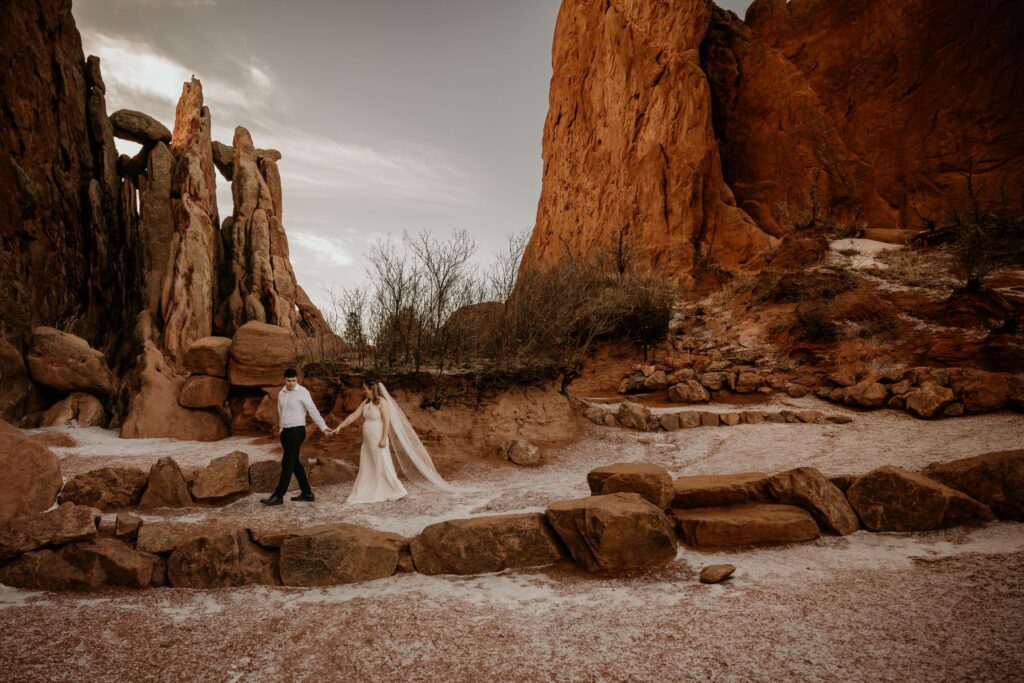 bride and groom walk down trail during colorado adventure elopement in garden of the gods.