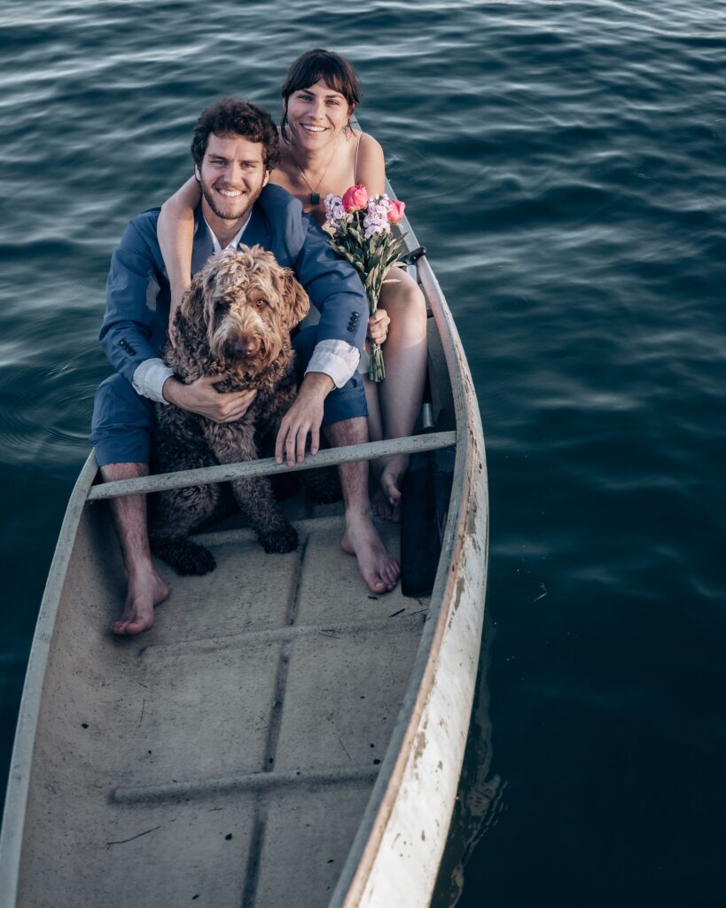 newlywed couple and dog in canoe during adventure elopement activities.