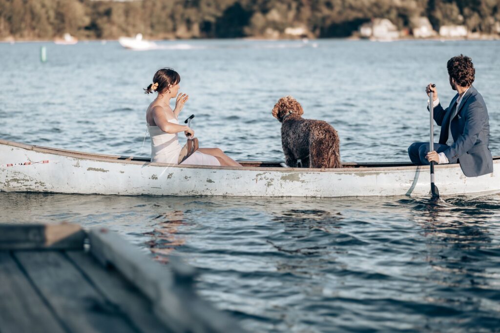 bride and groom with dog paddle out on canoe during adventure elopement photos.