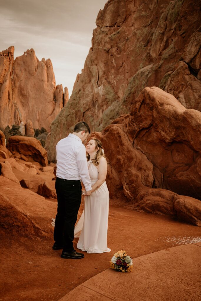 bride and groom stand in garden of the gods during colorado elopement photos.