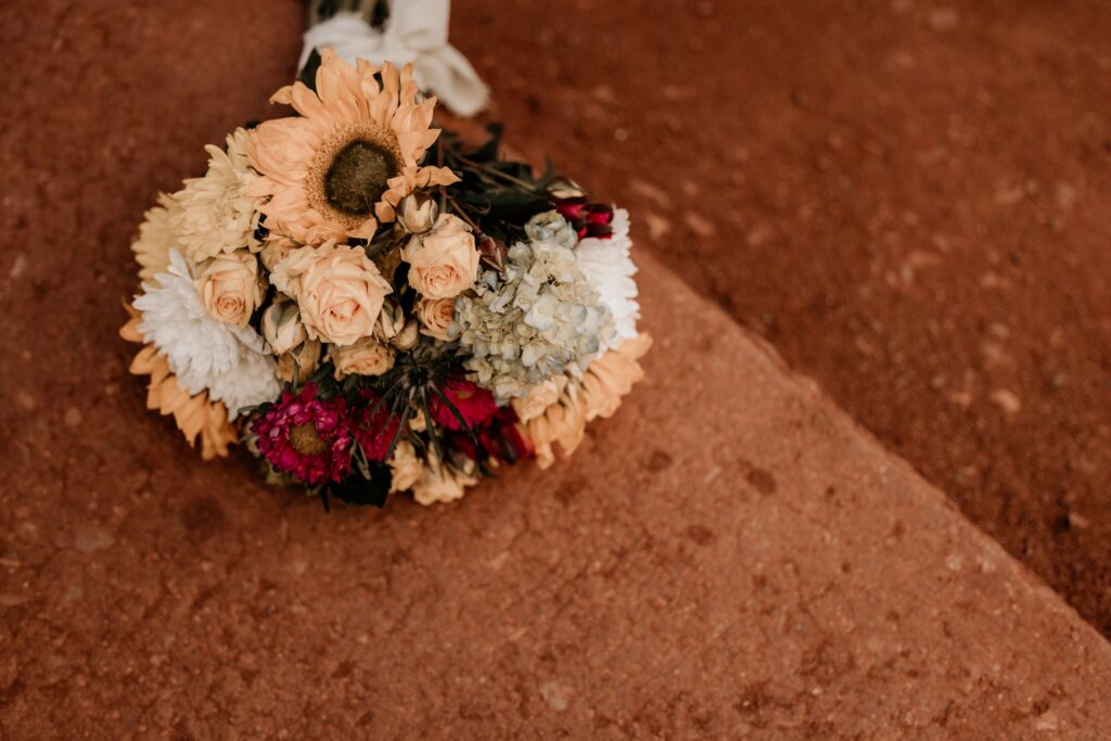Colorful bouquet sits on red rock during colorado adventure elopement.