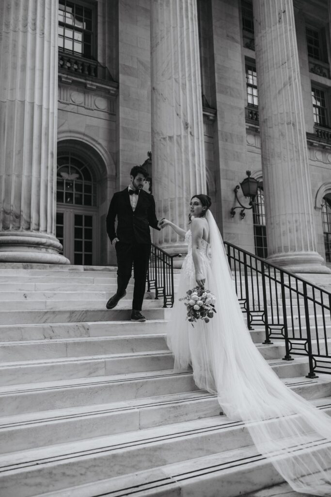 black and white image of bride and groom on steps during byron white courthouse wedding portraits.