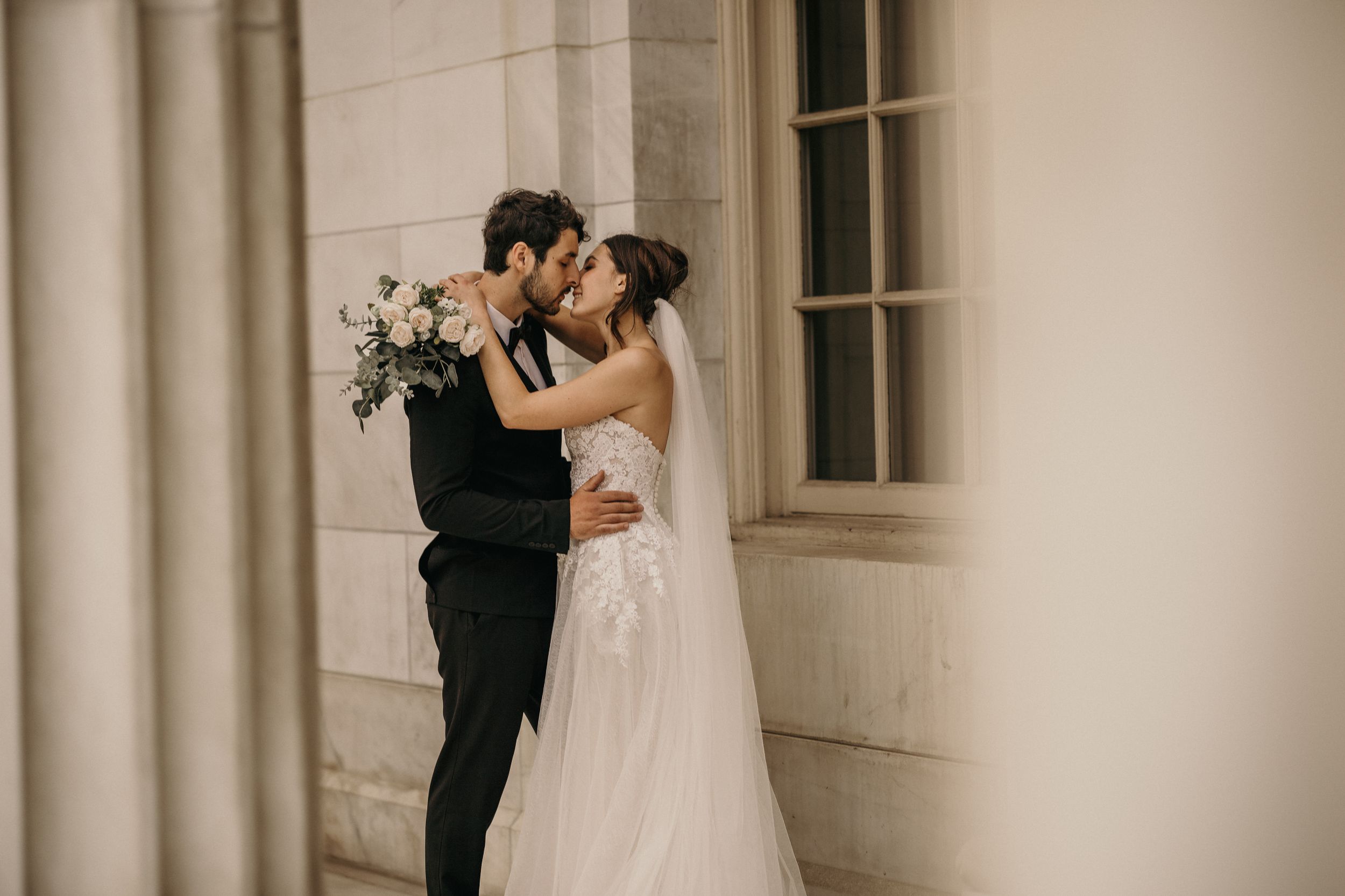 bride and groom kiss during wedding portraits in denver colorado.