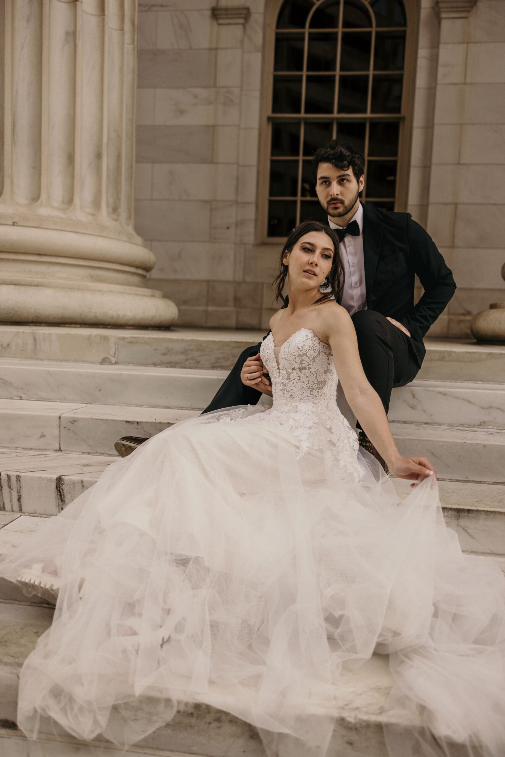 bride and groom pose on marble steps of byron white courthouse during wedding portrait photo session.