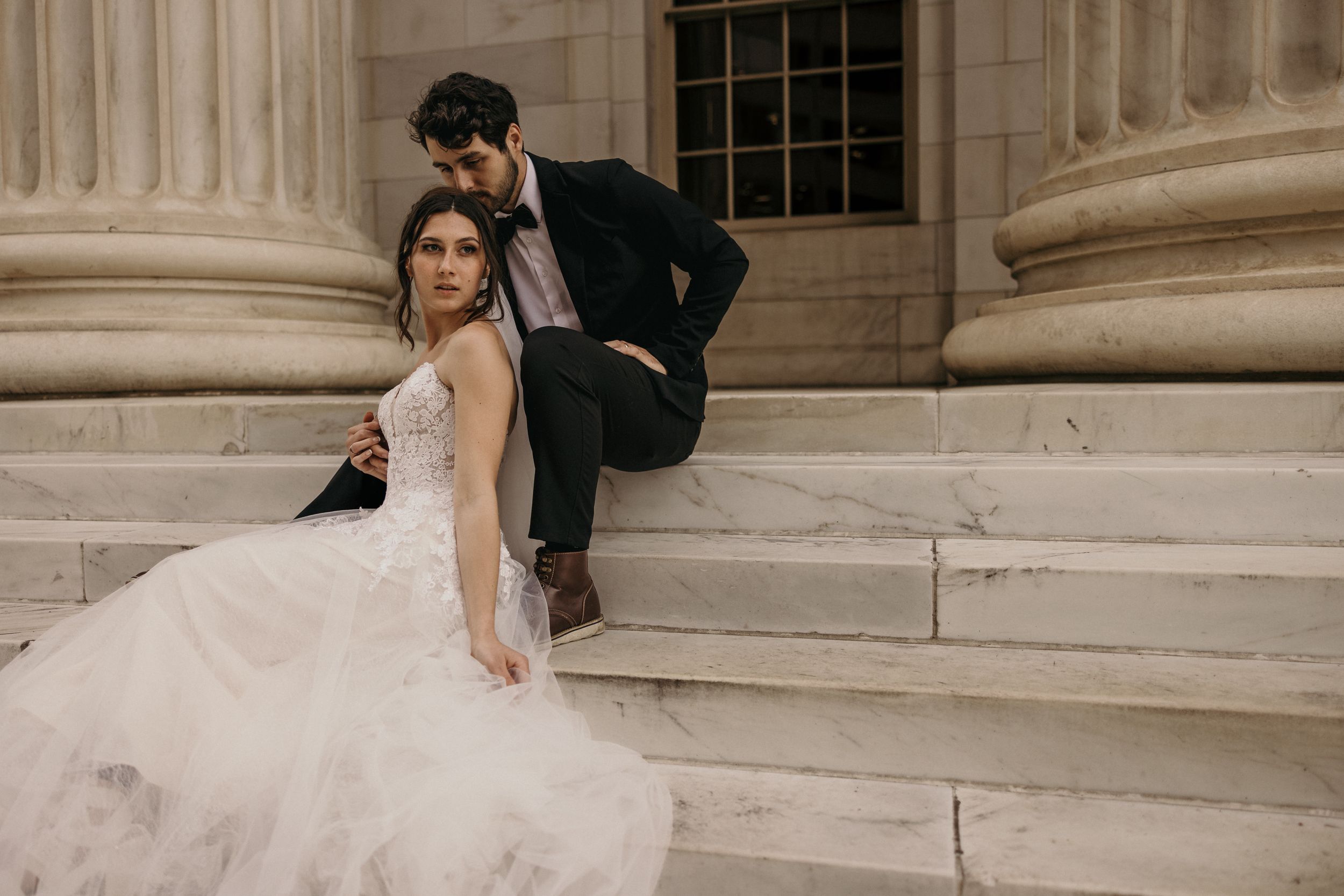 bride and groom pose on marble steps of byron white courthouse during wedding portrait photo shoot.