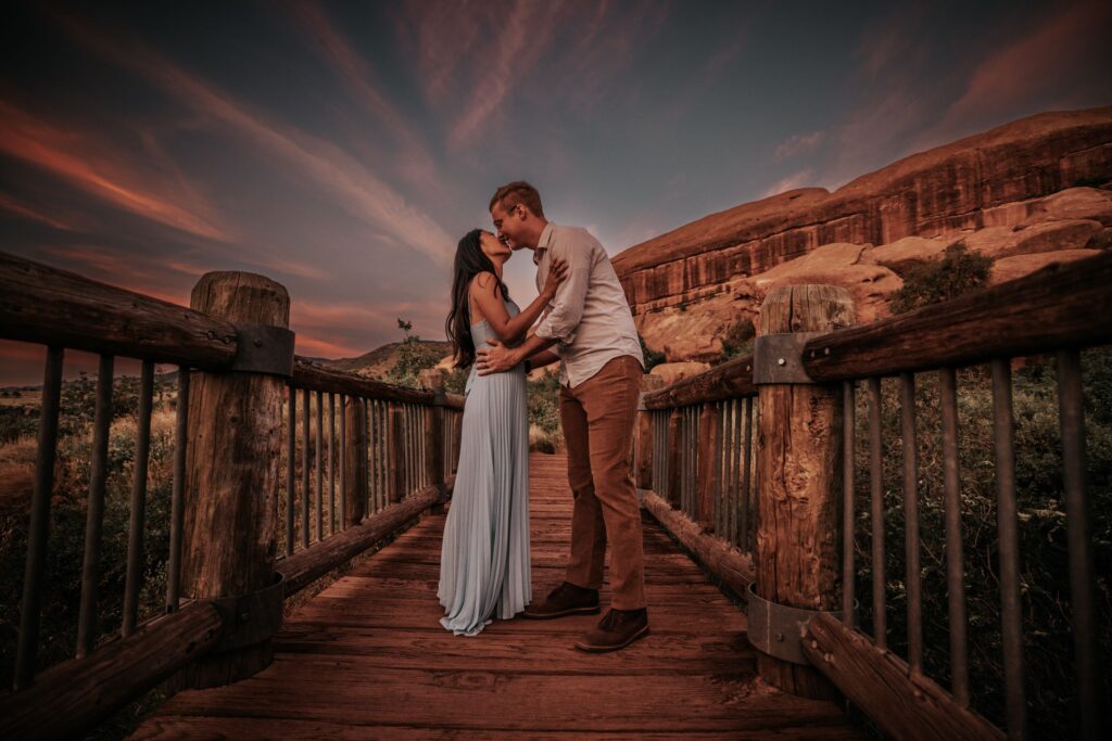 newlywed couple kisses on path at red rocks park + amphitheater during sunset adventure elopement in colorado.