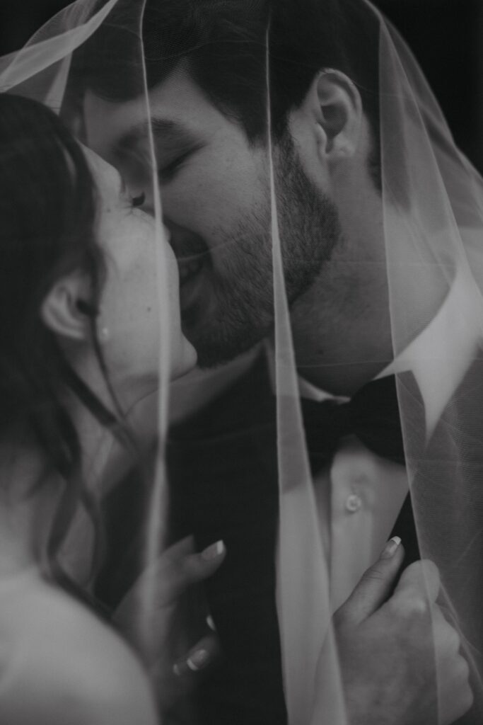 black and white image of bride and groom kissing under her veil during downtown denver bridal portraits.