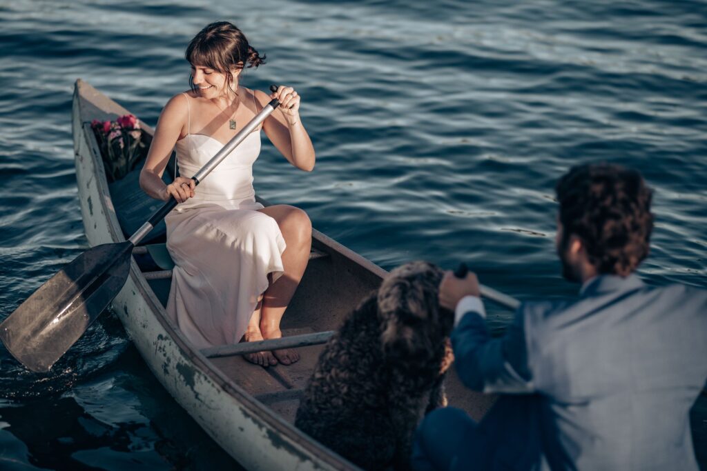 newlywed couple and dog in canoe during adventure elopement activities.