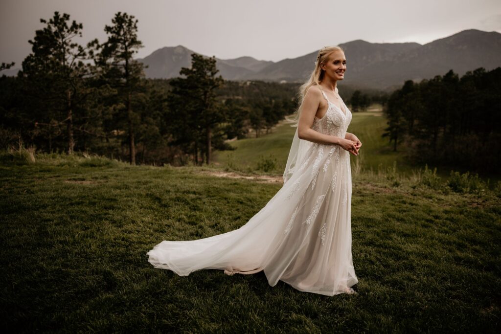Bride stands with mountains in the background, during wedding photos with colorado elopement photographer.