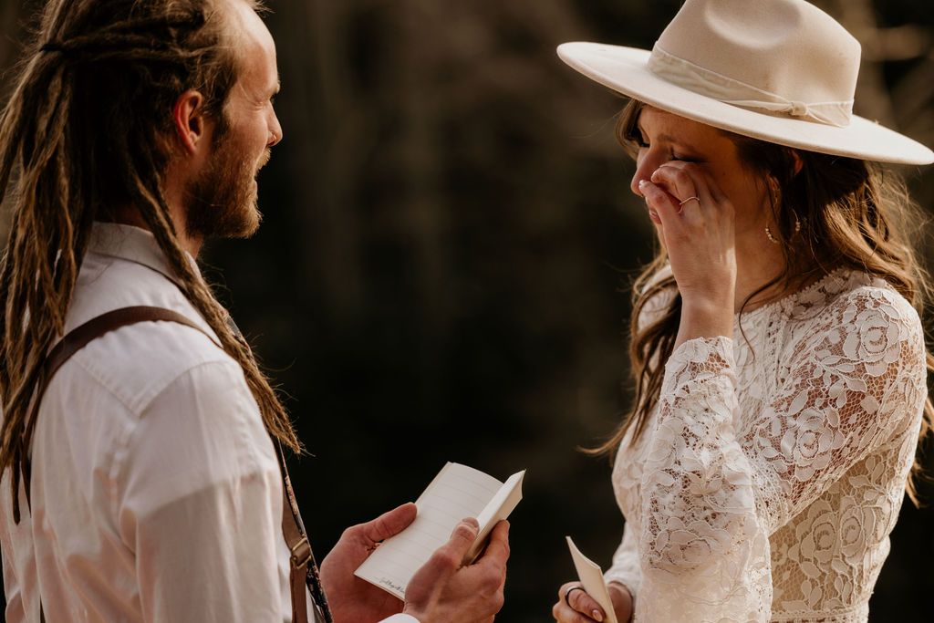 bride and groom say self-written vows during rustic wedding in colorado.