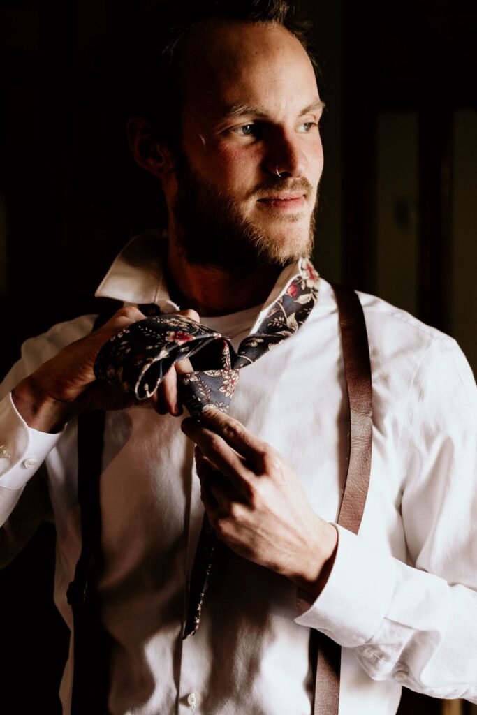 Close up image of person tying his tie for his Colorado Intimate Wedding Photos.