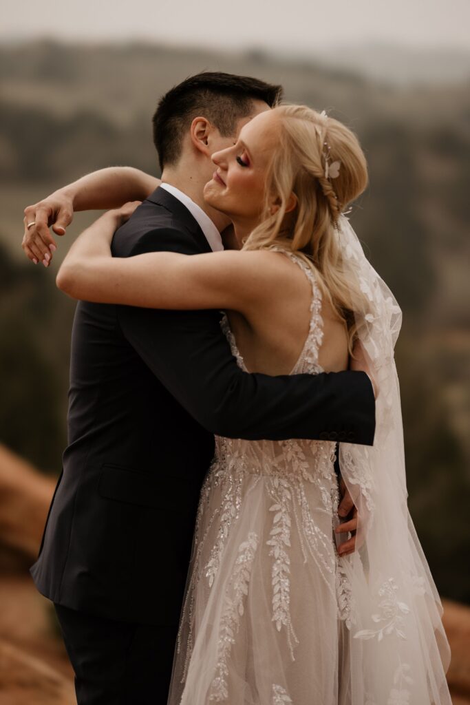 bride and groom hug colorado springs' garden of the gods during wedding photo session with colorado photographer.