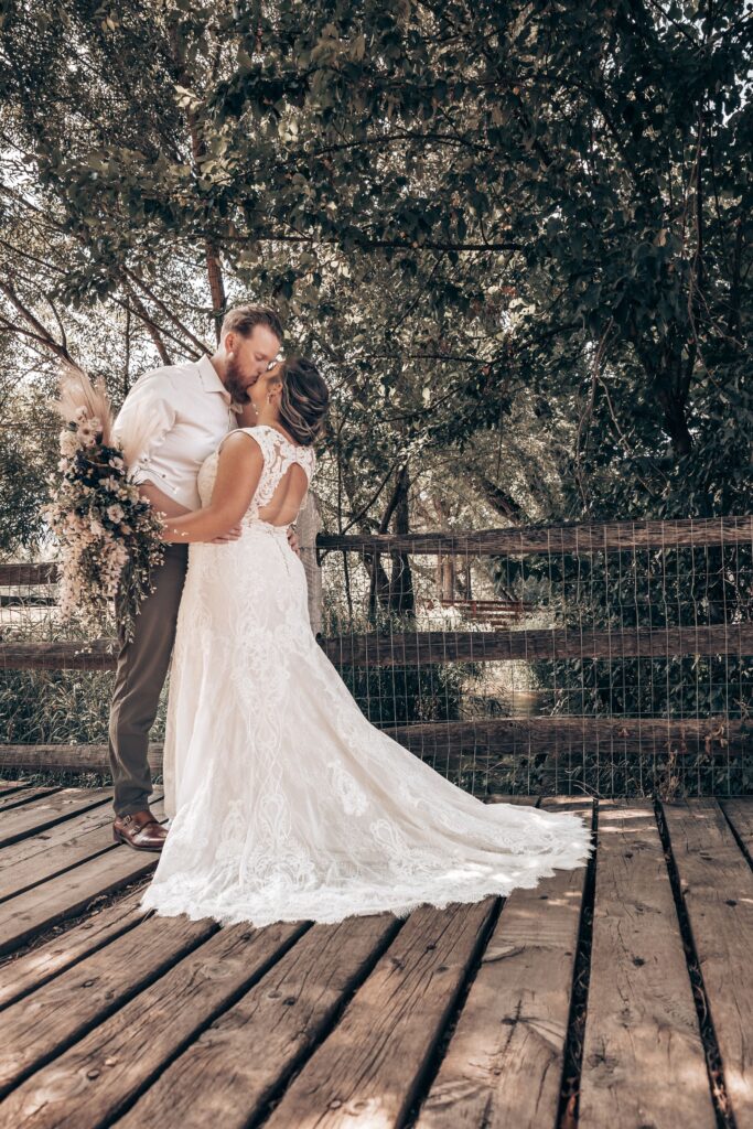bride and groom kiss under tree during colorado western wedding photos.