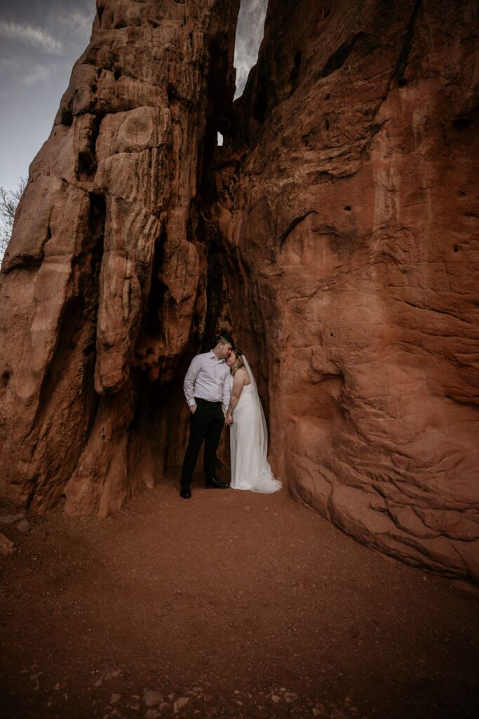 bride and groom embrace in the red rocks of garden of the gods during colorado elopement photos.