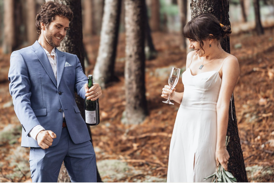 bride and groom pop a bottle of champagne during colorado adventure elopement photos.