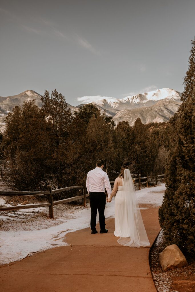 bride and groom walk down trail during colorado adventure elopement.
