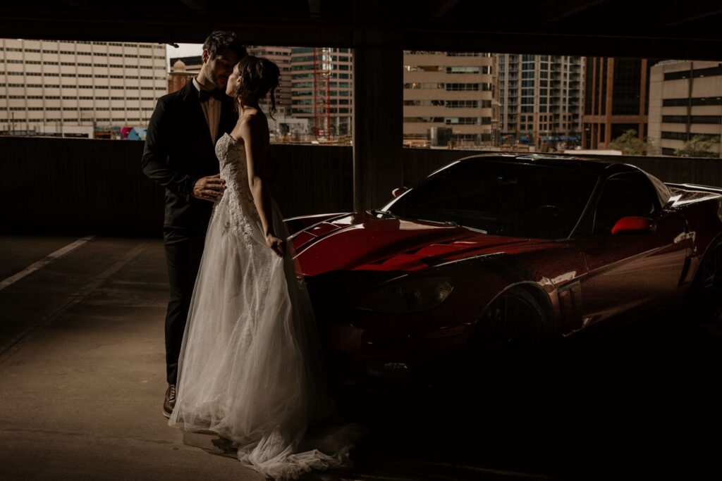 bride and groom pose beside red sportscar for colorado elopement photographer.