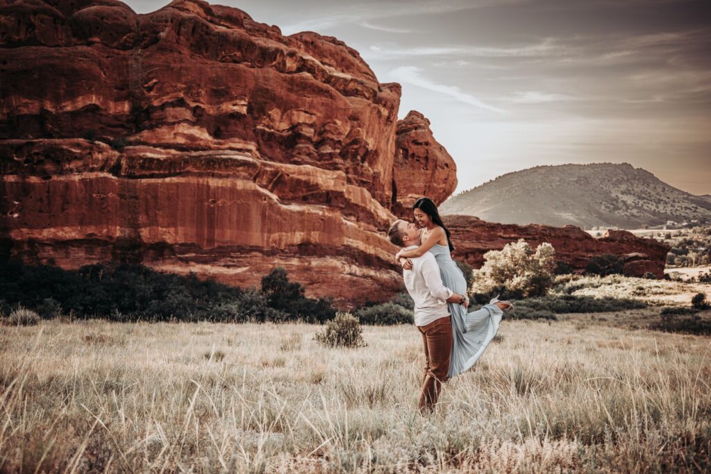 bride and groom walk down trail at red rocks park + amphitheater during colorado adventure elopement photo session.