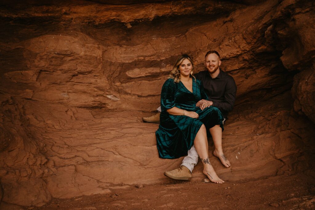 newlywed couple sits on red rock during adventure elopement photo session.