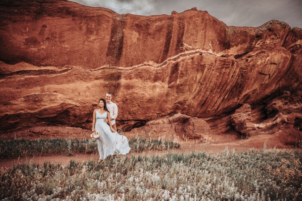 bride and groom walk down trail at red rocks park during colorado adventure elopement.