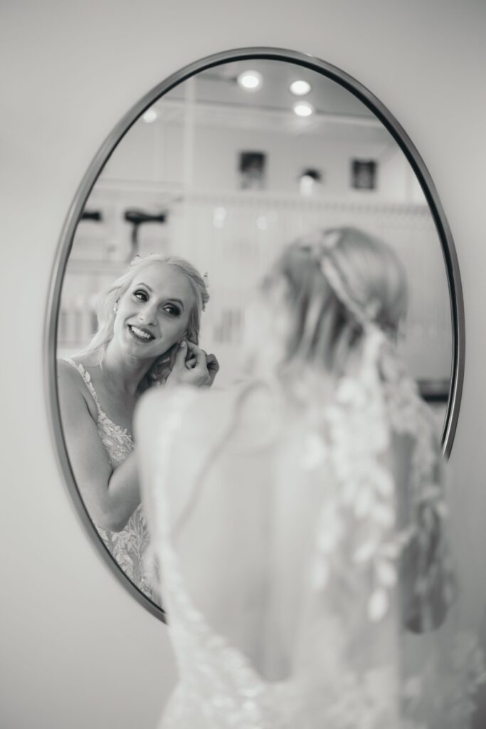 black and white image of bride looking in the mirror, during pre-wedding photos with colorado wedding photographer.
