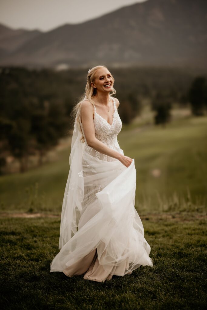 bride walks, holding her dress, during photos with colorado elopement photographer.