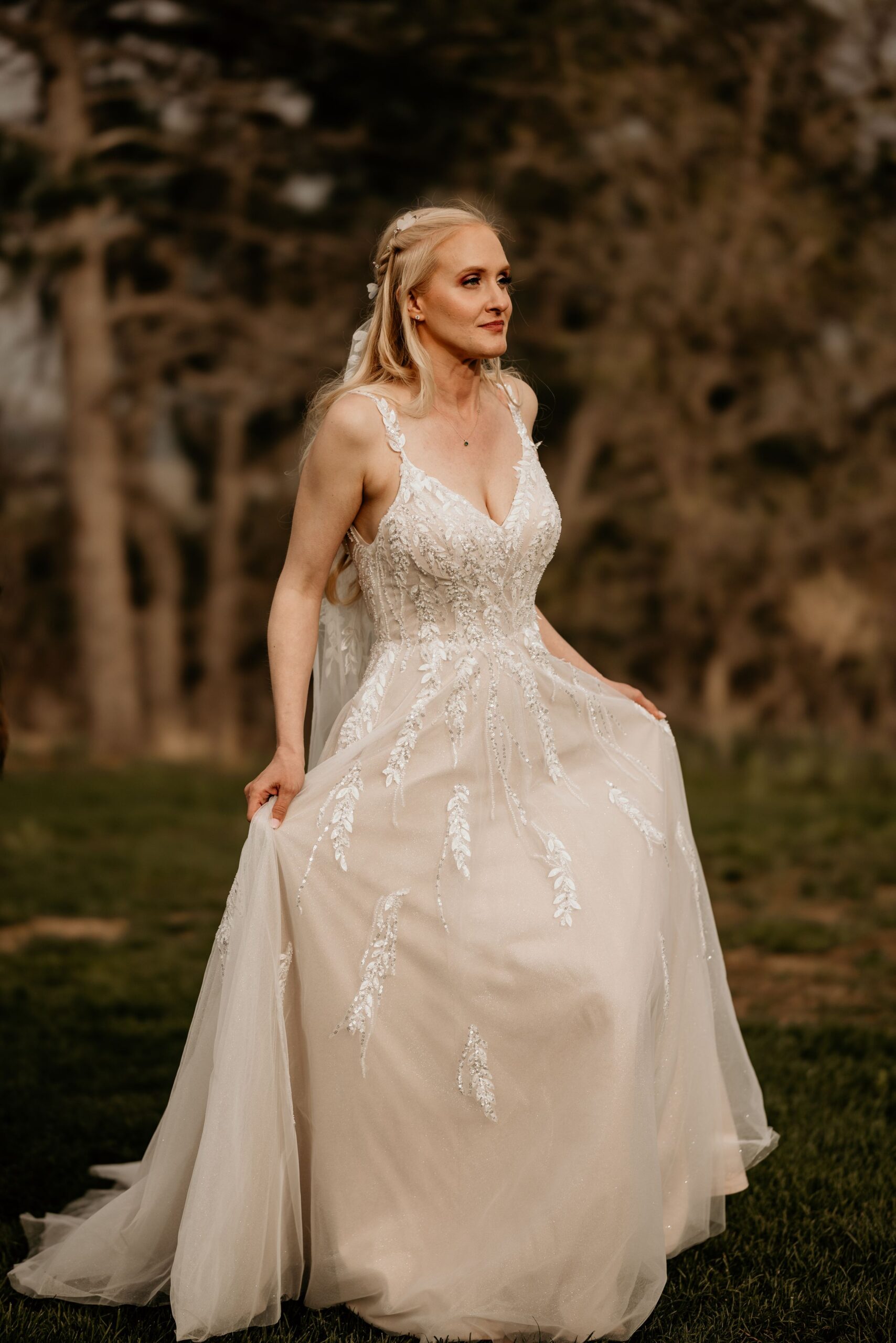 bride walks, holding her dress, during photos with colorado intimate wedding photographer.