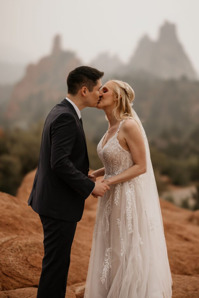 couple kisses at garden of the gods in colorado springs during wedding photo session.