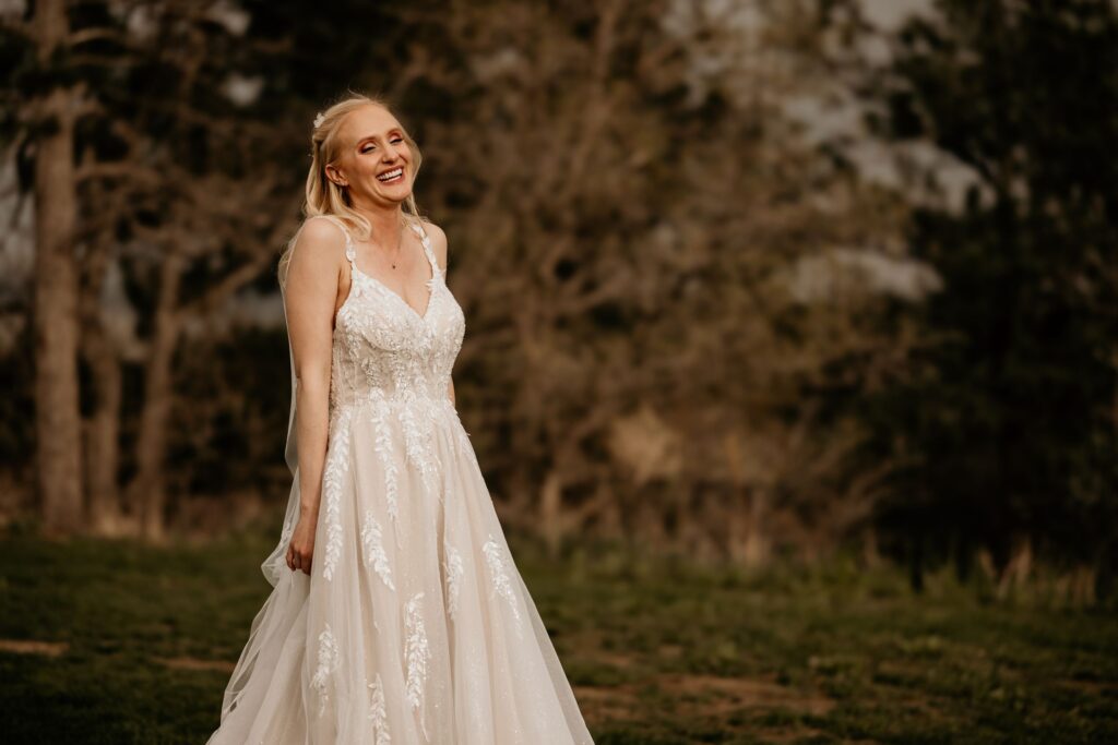 bride laughs, during wedding photos at the golf course with colorado elopement photographer.