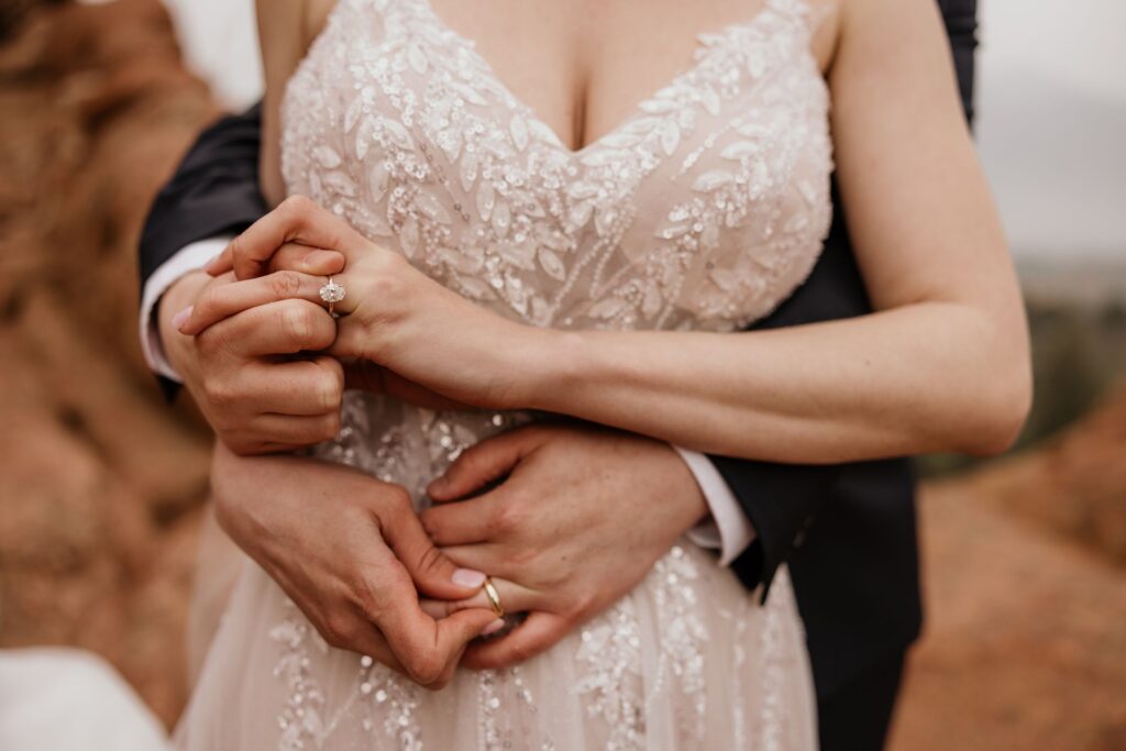 close up image of bride and groom showcasing their rings, during garden of the gods wedding photo shoot.