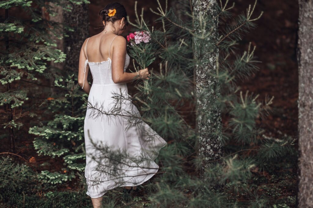 bride walks into mountain forest during colorado adventure elopement photo session.