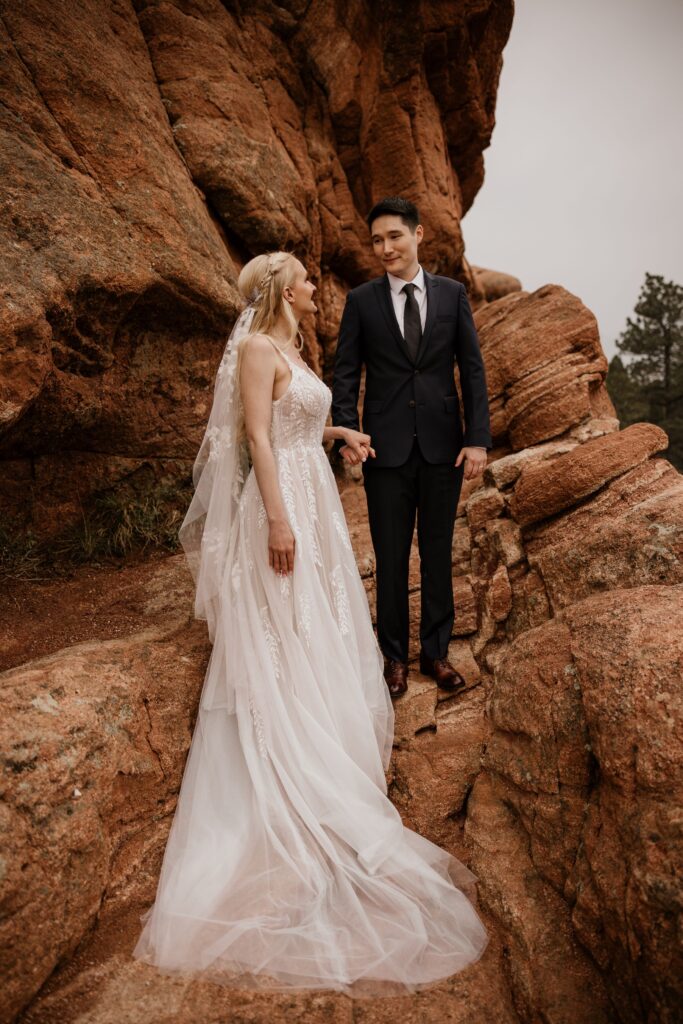 couple stands on red rocks at colorado springs' garden of the gods during wedding photo session.