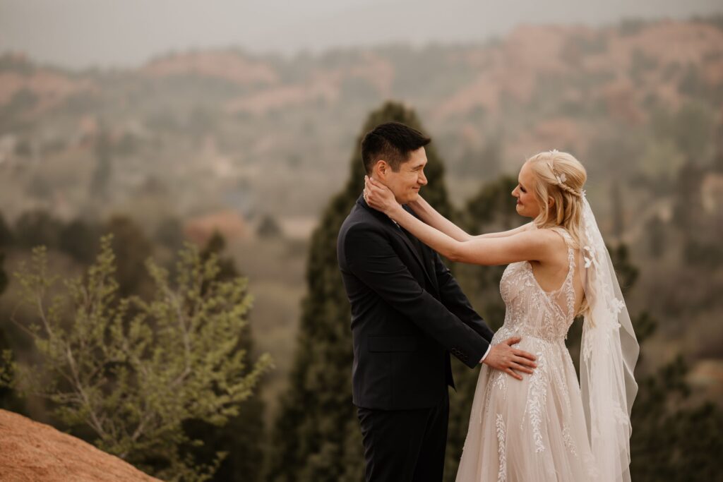 bride and groom embrace each other and smile during wedding photo session in garden of the gods colorado.