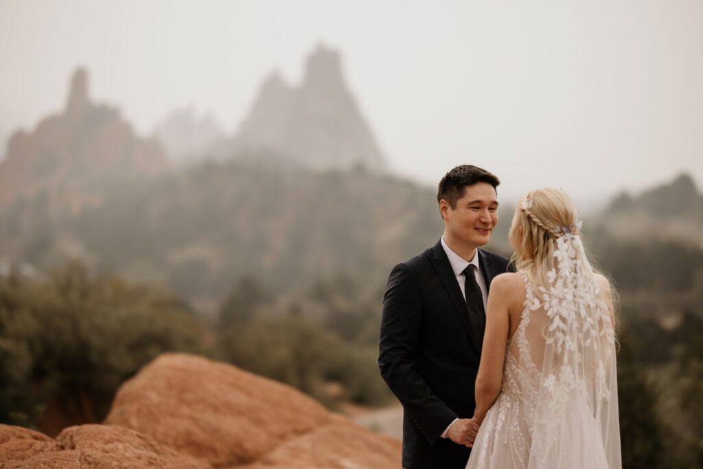 bride and groom hold hands at colorado's garden of the gods during wedding photo session with colorado photographer.