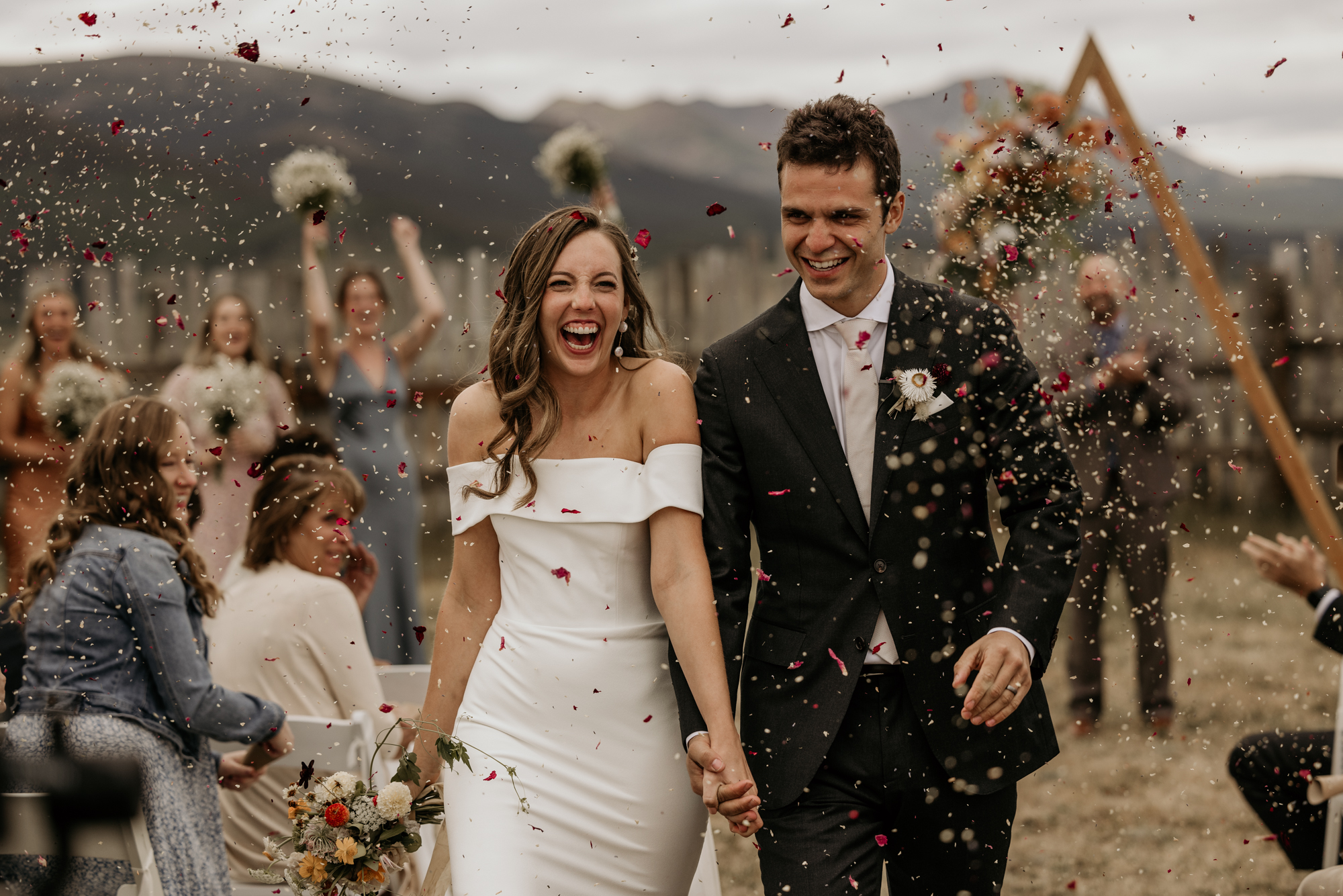 bride and groom walk down aisle to petal toss during Colorado mountain micro wedding.