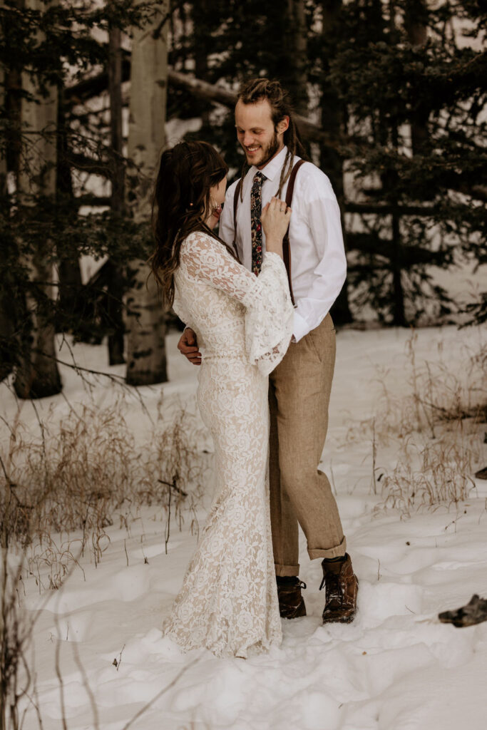 bride and groom embrace in the snowy colorado mountains during winter elopement.