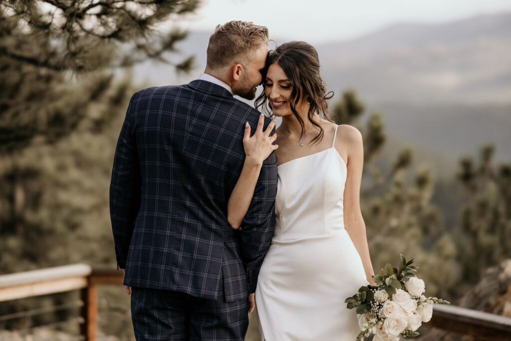 bride and groom embrace during sustainable Colorado mountain wedding.