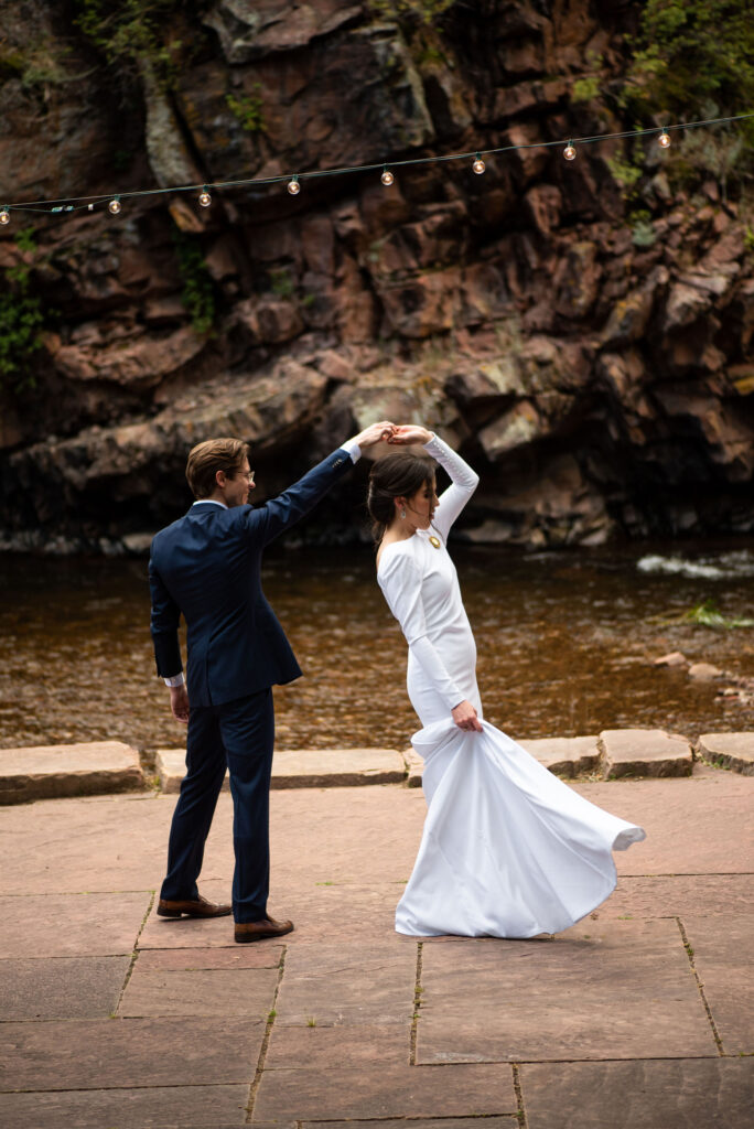 bride and groom dance by rivers edge during micro wedding at river bend venue in colorado.