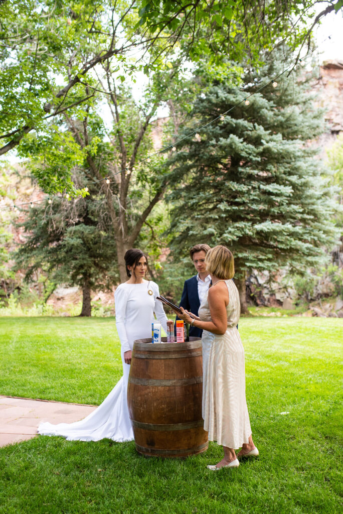 bride and groom do a candle intention setting ceremony at their colorado micro wedding at river bend venue.