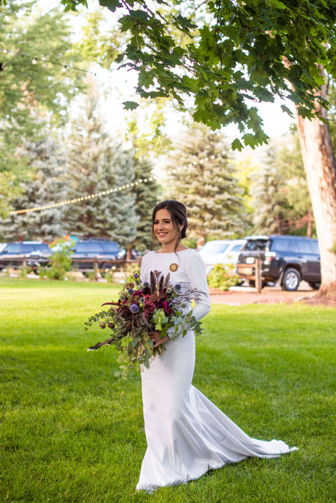 bride walks with wedding bouquet by Plume and Furrow for colorado micro wedding at river bend.