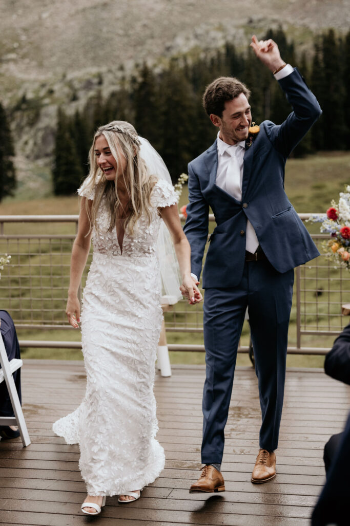 bride and groom walk down aisle after their ski mountain wedding ceremony at black mountain lodge in colorado.