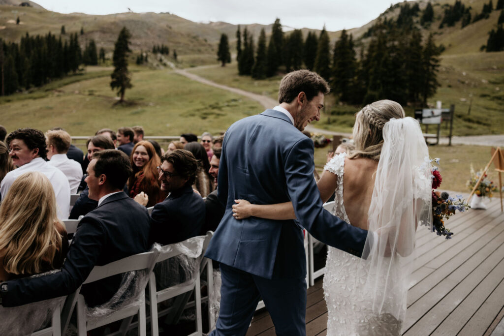 bride and groom walk down aisle during ski mountain wedding ceremony at black mountain lodge in colorado.